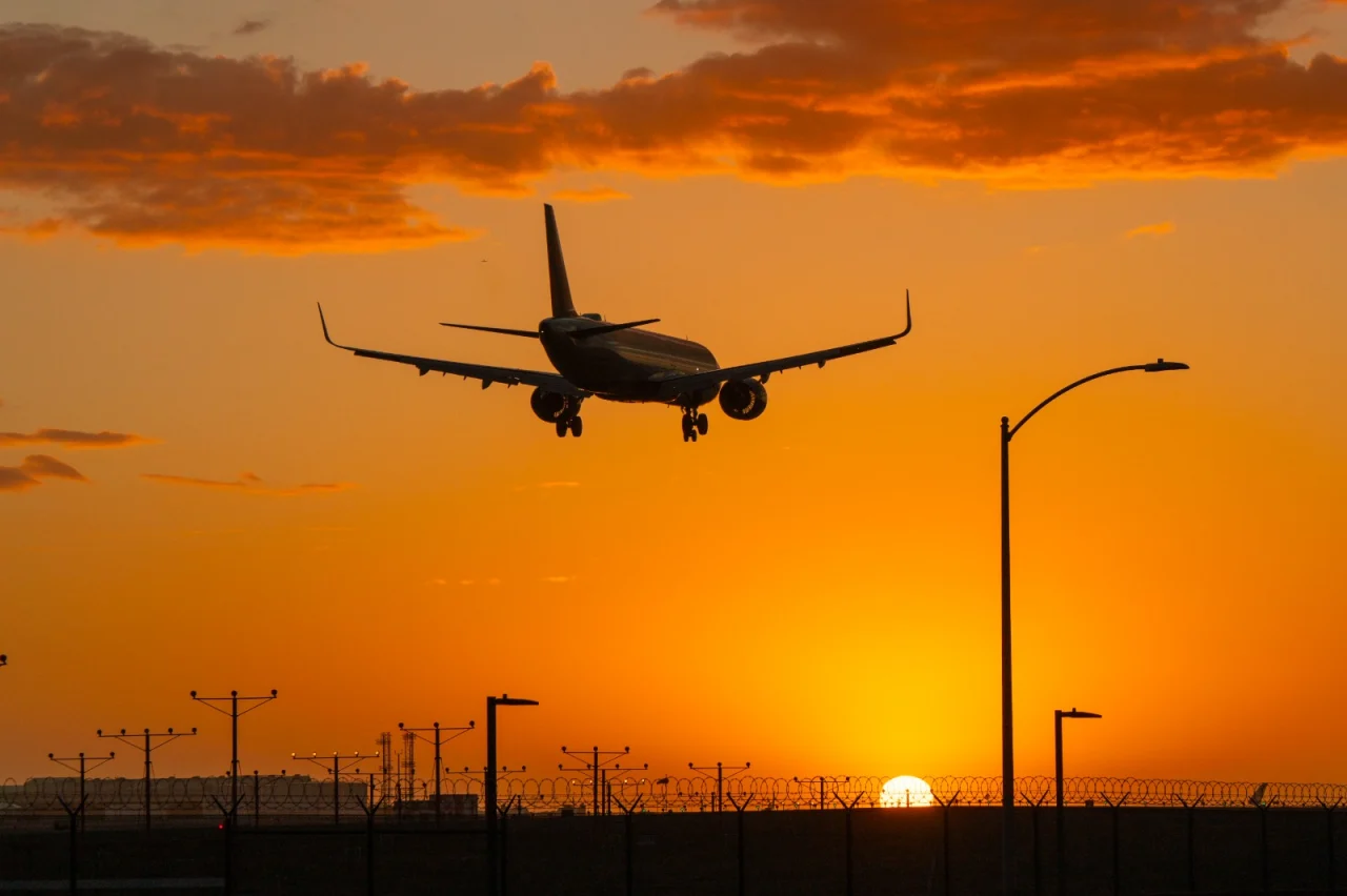 Aeronave aproxima-se de um aeroporto ao pôr do sol