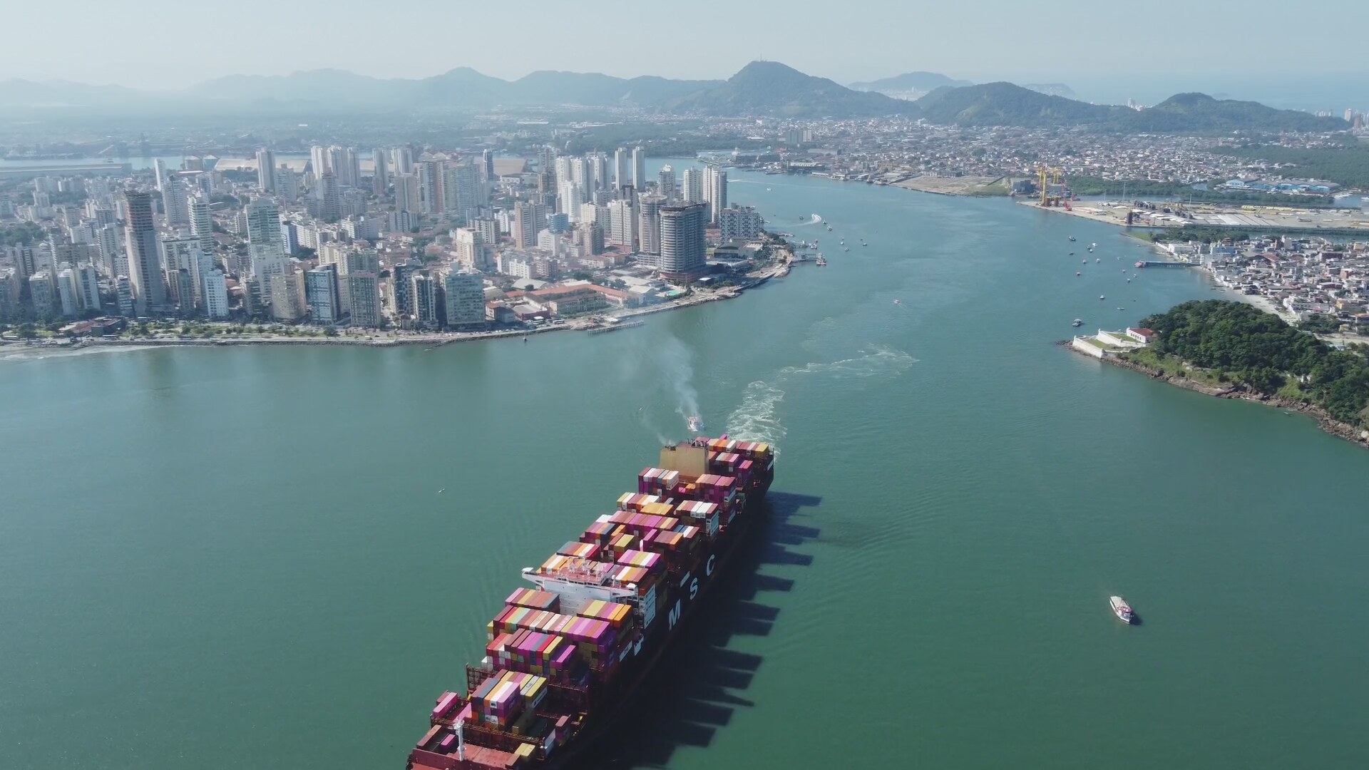 Terminal portuário com navio, contêineres e guindastes em operação