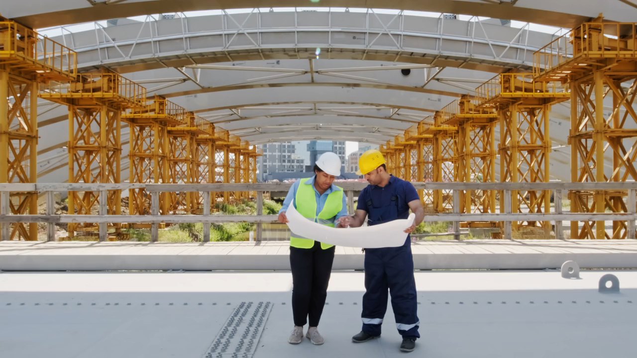 Two professionals analyze a technical plan on a construction site
