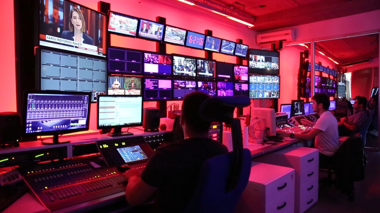 Sala de controle com operadores e múltiplas telas de monitoramento