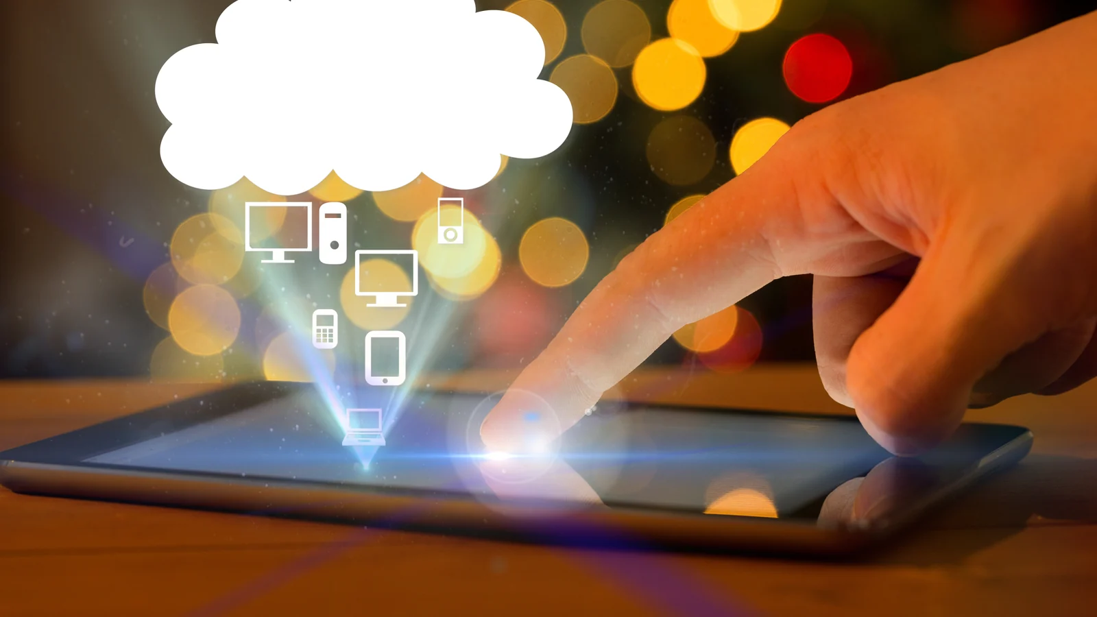 Hand touching a tablet connected to cloud devices and services