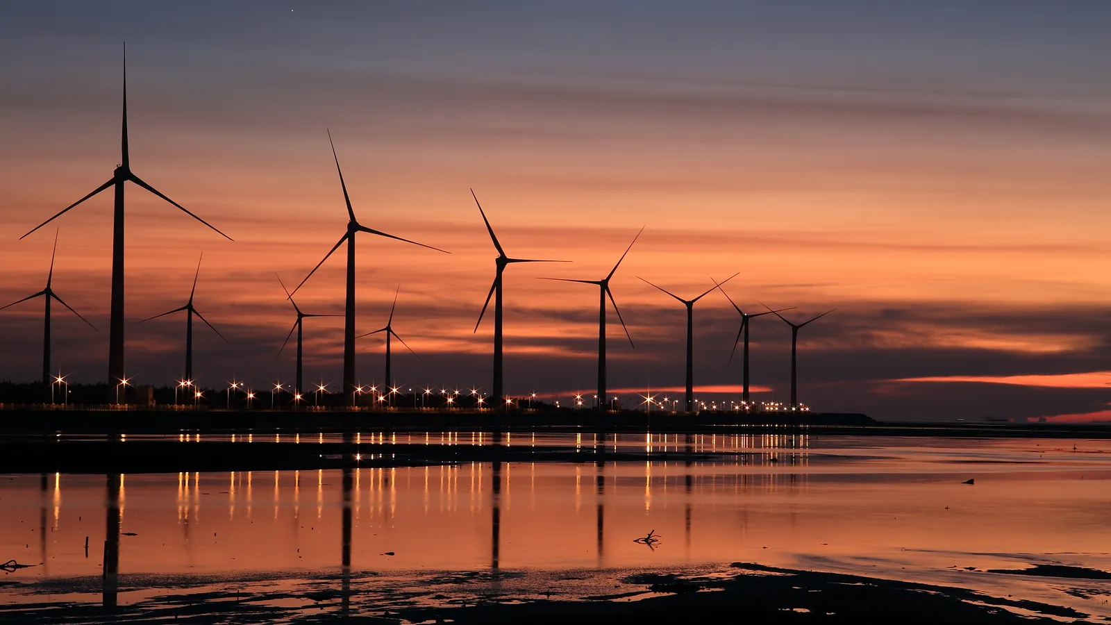 Wind turbine park at dusk reflected in the water