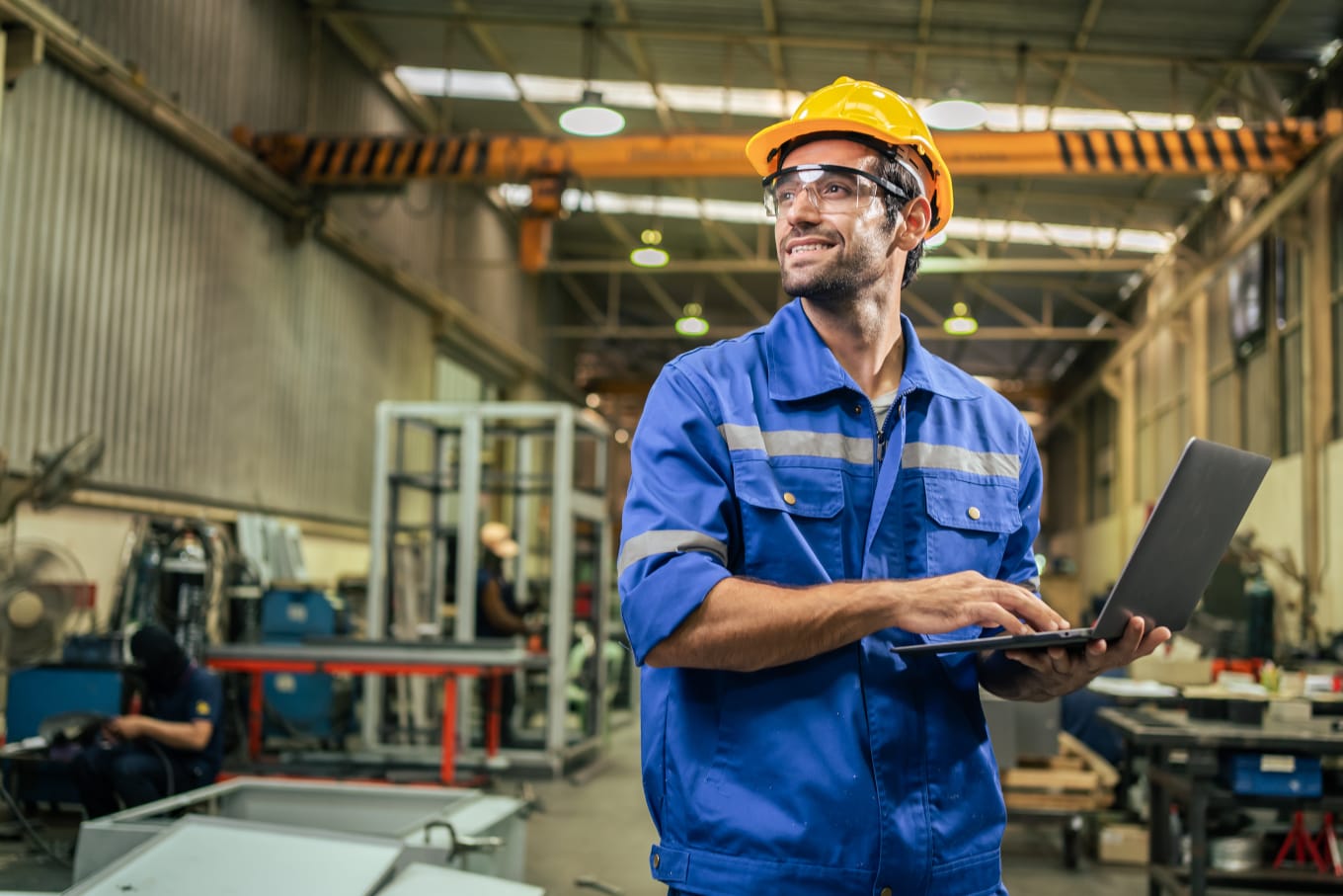 Técnico industrial usando notebook em uma área de produção
